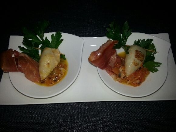 4 - Disposer vos calamars avec la sauce dans des assiettes de service légèrement creuses. Décorer avec quelques brins de persil plat et des lanières de tranches de jambon. Servir chaud ou tiède.