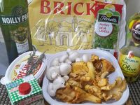 1 - Couper la queue des girolles, bien les nettoyer à l'aide d'un pinceau humide et les sécher avec du papier absorbant (ne pas passer sous l'eau pour conserver la saveur du produit) , peler et équeuter les champignons de Paris, couper les têtes en fines lamelles, émincer également les girolles de la même façon dans le sens de la longueur.