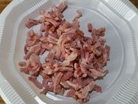 2 - Mettre le four à préchauffer th 5,5 (160°). Ciseler le persil plat et la ciboulette. Bien égoutter les lardons blanchis. Incorporer le tout au mélange de viandes, y verser un bouchon de cognac (facultatif). Bien mélanger à la main tous les ingrédients. Assaisonner avec du sel et du poivre.