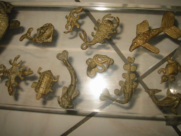 Fruits en bronze trempés dans un bain d'or, lance tribale, joueur de Cora, buffle et ses oiseaux, poids Baoulé servant à peser l'or