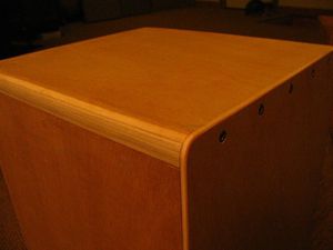 Il est important de ne pas trop serrer les 5 vis de la partie supérieur de l'instrument car cela permet à la plaque avant de claquer sur le corps du CAJON. J'ai testé différents matériaux pour la table de frappe dont du plexi blanc que j'avais à gauche, le son était idéal, bien clair. Mais malheureusement il n'a pas fait long feu... Il a cassé sous la préssion des frappes !!! Sinon ce qui s'en rapproche le plus c'est l'isorel très dense avec un coté blanc laqué, c'est ce que j'utilise en ce moment, coté blanc à l'intérieur pour le contact avec le métal du timbre. Je trouvais qu'avec le contreplaqué de 4mm le son était "carton".