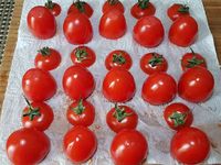 1 - Mettre les oeufs à cuire dans une casserole d'eau bouillante pendant 9 mn. Laver et sécher les mini tomates en gardant les pédoncules. Couper la partie supérieure, épépiner l'intérieur, retourner les tomates et leurs chapeaux sur du papier absorbant. Emietter le pain de mie dans un récipient, verser dessus le vinaigre, bien écraser à la fourchette. Peler et dégermer l'ail et l'intégrer pressé à la préparation.
