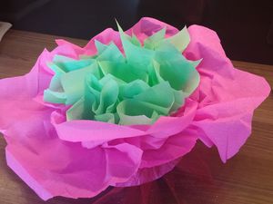 Pour la déco : Prenez 7 gobelets en plastique. Agrafer les ensembles. Prendre du joli papier crépon de couleur de votre choix (j'ai choisit rose et vert mais vous pouvez en prendre plus) de 80x80. Poser une assiette à dessert (en plastique c'est très bien, ça ne déchire pas le papier) sur les feuilles de papier crépon, déposez y les gobelets assemblés. Avec un joli nœud, resserrez les feuilles de papier crépon sur les gobelets. Découper 7 feuilles de papier crépon (vert pour moi) de 10x10. Les déposer dans chaque gobelets. Insérer les cupcakes dans chaque gobelets. Il vous reste à décorer chaque cupcakes de crème au beurre ou autre. Effet garantit !!!  