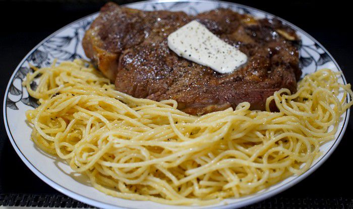 Assiette de côte de boeuf au four accompagné de spaghettis.