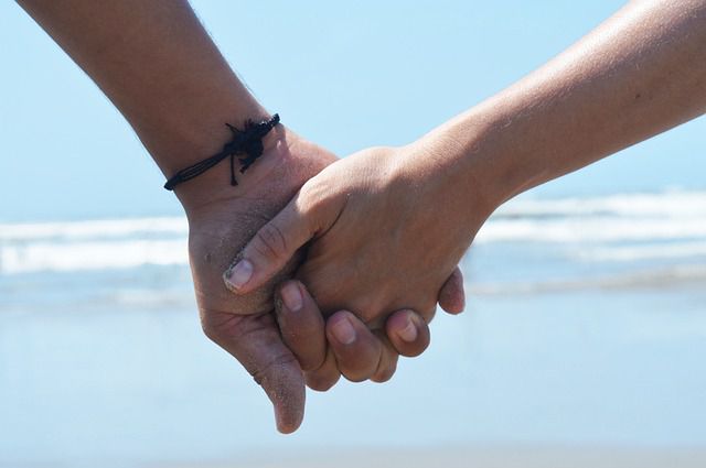 Un couple se tenant la main en bord de mer