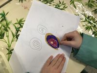 Nous avons dessiné des cercles concentriques au crayon gris que nous avons coloriés avec des pastels gras.