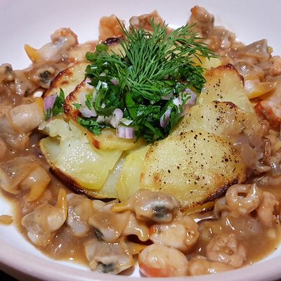 Gâteau de pommes de terre confites, coquillages et crustacés sautés au gingembre et herbes