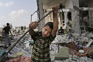 Palestinians inspect damages of the Nada Towers at a residential neighborhood in Beit Lahiya