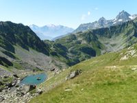 Un des lacs du Vénétier avec une vue sur Belledonne et la Maurienne dont le glacier de l'Etendard. Le sentier continue vers le col de la Jasse.