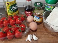 1 - Mettre les oeufs à cuire dans une casserole d'eau bouillante pendant 9 mn. Laver et sécher les mini tomates en gardant les pédoncules. Couper la partie supérieure, épépiner l'intérieur, retourner les tomates et leurs chapeaux sur du papier absorbant. Emietter le pain de mie dans un récipient, verser dessus le vinaigre, bien écraser à la fourchette. Peler et dégermer l'ail et l'intégrer pressé à la préparation.