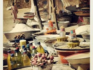 photographie de Soraya Adibord , représentant les marchés dans les peitits villages du désert du Sahara (dans la régions de l'Ennedi  et de Faya situés au nord du Tchad ) .Pour leur survie le commerce est essentiel :vente de bettaille ,dattes,thé,céréales (...) .