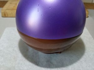 2 - Faire fondre le chocolat avec précaution au micro-ondes dans un bol. Laisser légèrement tiédir. Gonfler un ballon à la taille voulue et en tremper la base délicatement dans le bol de chocolat. Poser un petit disque de chocolat sur du papier sulfurisé et poser la base du ballon enrobé de chocolat sur ce petit disque. Laisser refroidir complètement. Décoller délicatement la coupelle du papier sulfurisé avec un couteau. Puis appuyer doucement sur le ballon sur tout le tour de la coupelle pour dégager le chocolat. Faire ensuite une légère entaille dans le haut du ballon (près du noeud) pour qu'il se dégonfle lentement. Votre coupelle est prête à être garnie.
