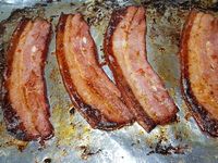 2 - Une fois le temps de marinade écoulé, sortir les tranches du réfrigérateur, les égoutter, les disposer sur une plaque allant au four recouverte de papier alu et les passer au grill du four 5 à 6 mn sur chaque face (selon les fours et l'épaisseur des tranches). Vous pouvez également les faire griller au barbecue ou à la plancha. Pendant la cuisson, préparer une petite salade de tomate en  lavant, séchant des tomates rouges, les couper en quartiers, les épépiner et les assaisonner avec un peu d'huile de marinade et du persil haché, saler et poivrer.  Servir en accompagnement des tranches de poitrine grillées.