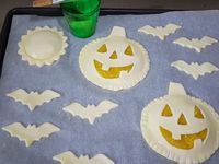 3 - Garnir les 2 disques pleins des têtes de citrouille avec la compote de mangue et l'une des petites rosaces. Recouvrir avec les têtes de citrouille évidées en soudant bien les bords avec un peu d'eau, faire de même avec la rosace. Décorer les bords avec un couteau comme sur la photo.  Dorer le tout au pinceau avec le jaune d'oeuf délayé dans un peu d'eau. Enfourner th 6 (180°) pour 15 mn environ en surveillant. La pâte doit être gonflée et dorée. Laisser refroidir et servir tiède ou froid en dessert gourmand à vos petits amateurs d'Halloween.