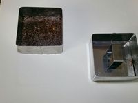 3 - Moudre les noix du Brésil en poudre. Dénoyauter les dattes et les passer également au mixeur avec le cacao jusqu'à obtenir une pâte homogène. Placer cette pâte dans un bol et y incorporer la poudre de noix, bien mélanger et rouler en boule. Diviser la préparation ainsi obtenue et la placer dans des formes carrées (ici 8cm x 8cm ) ou rectangulaires ou rondes selon vos désirs, et tasser. Placer au réfrigérateur.