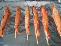 1 - Préparer à l'avance la marinade pour les gambas en ajoutant successivement les ingrédients suivant dans un récipient pouvant contenir les brochettes de gambas : un bon fond d'huile d'olive, l'ail pelé, dégermé et écrasé, le gingembre râpé, les épices et les herbes, le sel et le poivre. Mettre les gambas à mariner dans cette préparation pendant 2 à 3 h en les retournant de temps en temps pour bien imprégner toutes les faces. Découper le fromage manchego en petits cubes. Egoutter les brochettes de gambas pour retirer l'excédent d'huile, les déposer sur une plaque allant au four recouverte de papier aluminium et les passer au grill pendant 2 à 3 mn sur chaque face.
