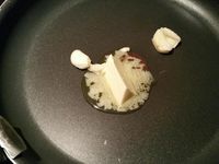 3 - Peler et écraser la gousse d'ail avec le plat d'un couteau. Faire revenir l'ail dans une poêle avec le beurre, rajouter le chou égoutté et laisser étuver à couvert, puis incorporer la moitié de la sauce à la crème, rectifier l'assaisonnement si besoin . Remettre le four à préchauffer th 6 (180°). Découper les pommes de terre en rondelles de 2 à 3 mm d'épaisseur, tailler la saucisse en rondelles de la même façon. Remettre le cercle autour de la pâte, étaler une couche de chou en tassant un peu, ôter le cercle et disposer les rondelles de saucisse, puis celles de pommes de terre au centre. Enfourner le tout pour 10 mn environ th 6 (180°). Déguster dès la sortie du four en rajoutant un peu de sauce au centre de la tarte fine pour un bel effet visuel.