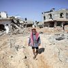 An elderly Palestinian man checks the damage caused by Israeli strikes in Gaza Strip