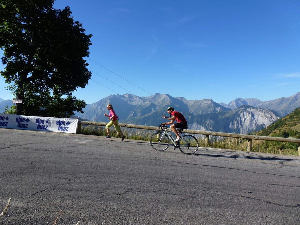 Joël en plein effort dans la montée de l'Alpe d'Huez, accompagné par Michèle et franchissant la ligne d'arrivée