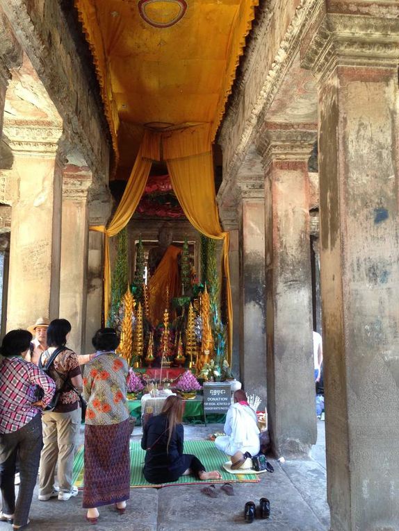 People praying to Buddha and an image of headless Buddha (center).
